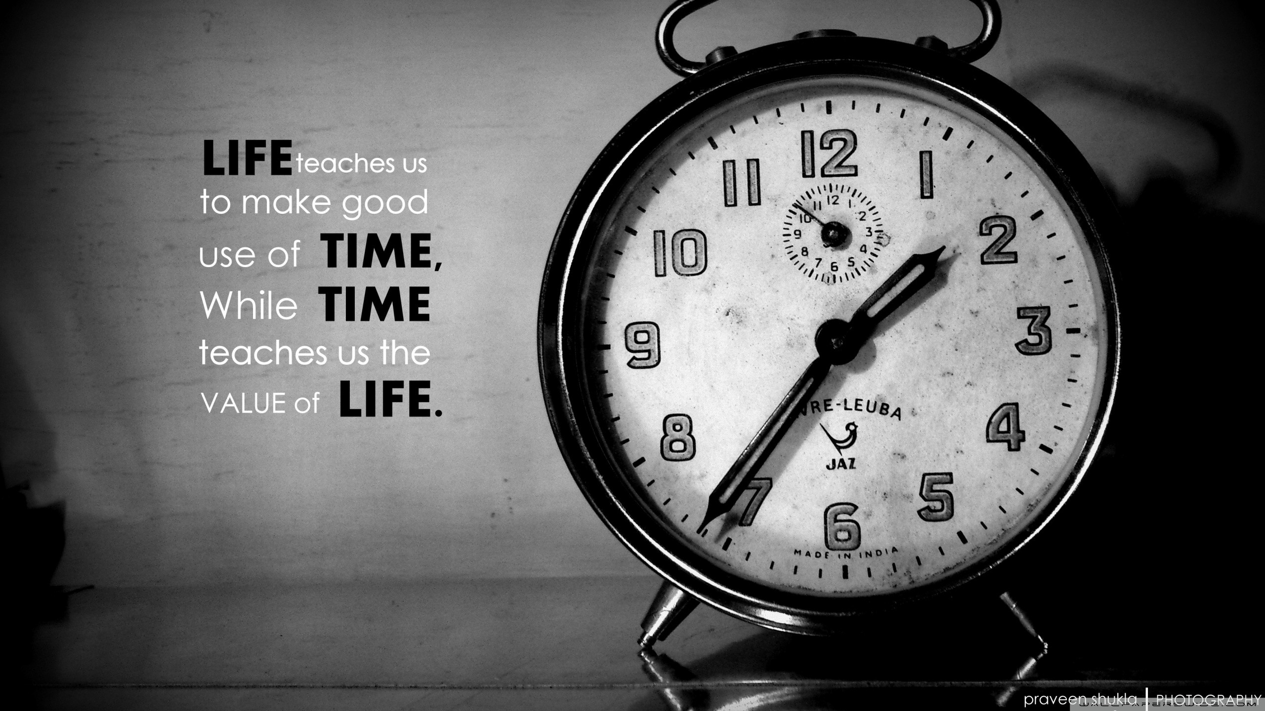 HD desktop wallpaper featuring an antique clock with an inspirational quote on the value of time and life.