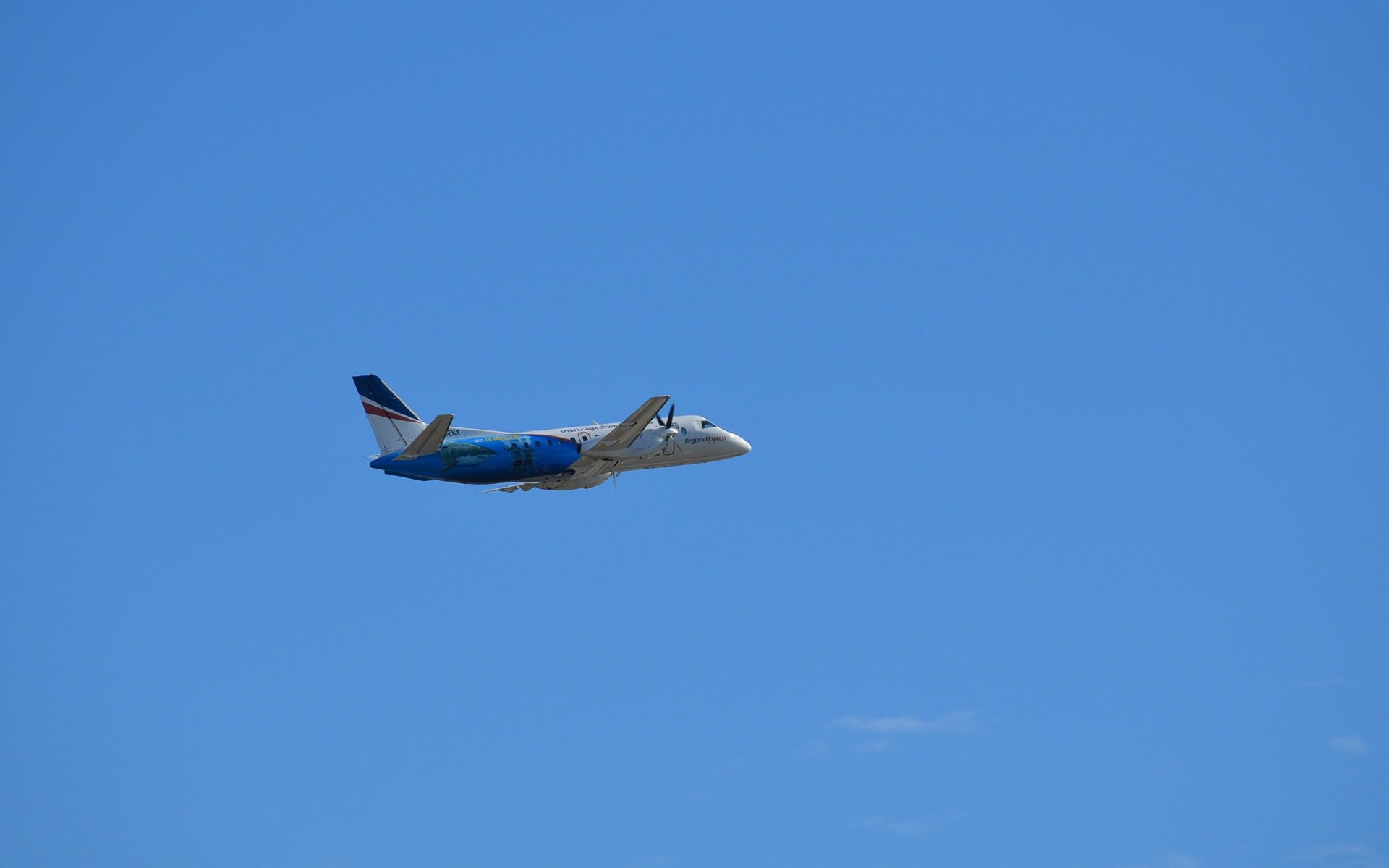 HD desktop wallpaper featuring a Saab 340B aircraft flying against a clear blue sky, showcasing the Saab 340 airplane vehicle in flight.