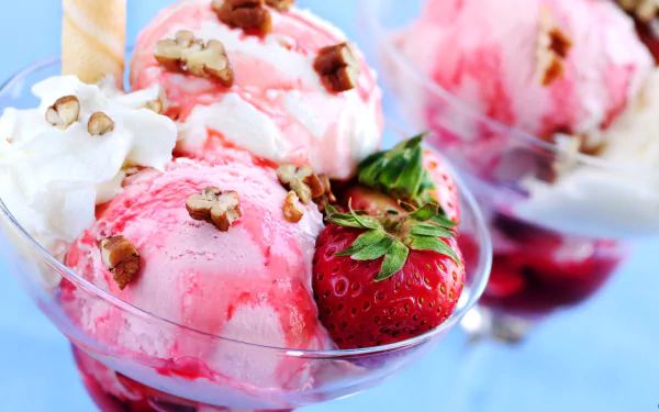 HD desktop wallpaper featuring scoops of delicious strawberry ice cream topped with whipped cream, walnuts, and fresh strawberries. The background is blurred to highlight the vibrant dessert.