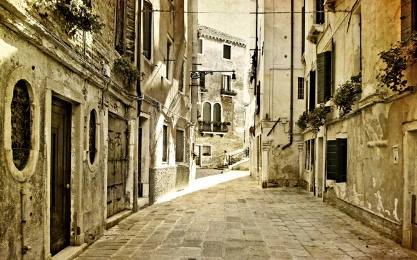 HD PC desktop wallpaper of a narrow, sunlit man-made alley with aged stone buildings and architectural details lining the cobblestone path.