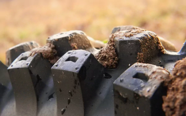 Close-up of a motocross tire showing mud and dirt, highlighting the rugged details essential for off-road sports. This 4K Ultra HD image serves as a dynamic desktop wallpaper.