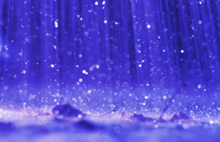 A captivating HD desktop wallpaper featuring vibrant purple hues as rain pours down, shimmering droplets creating a tranquil and atmospheric background.