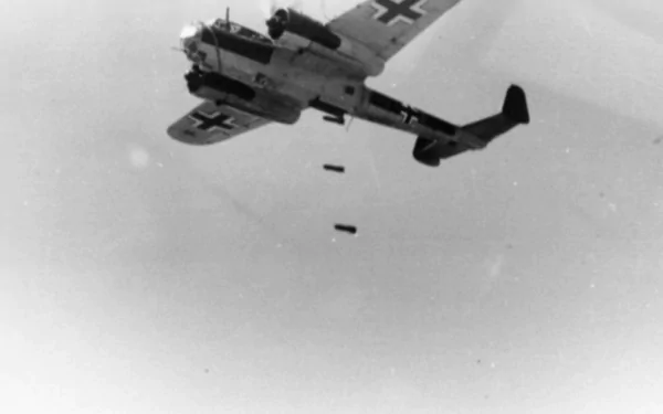 Black-and-white HD PC desktop wallpaper showing a military Dornier Do 17 bomber releasing bombs against a pale sky.