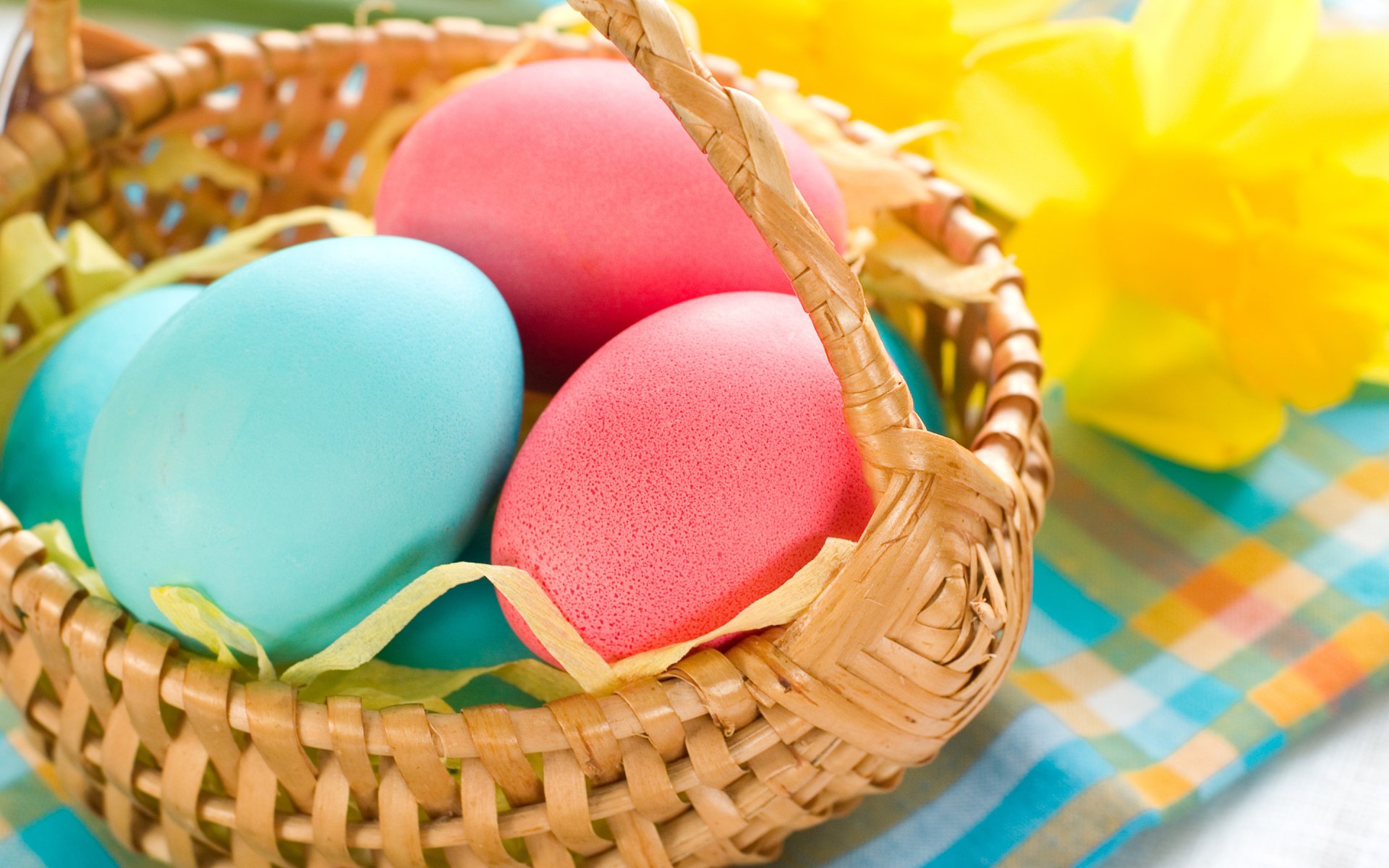 HD desktop wallpaper featuring colorful Easter eggs in a woven basket with a bright, cheerful background evoking the holiday spirit.