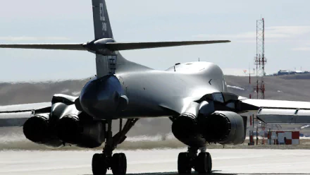 HD PC desktop wallpaper featuring the rear view of a Rockwell B-1 Lancer military bomber on a runway.