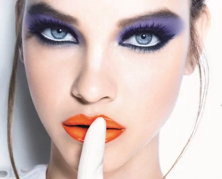 A striking HD desktop wallpaper featuring celebrity Barbara Palvin, showcasing her bold makeup with violet eyeshadow and vibrant orange lips, creating a captivating and modern aesthetic.
