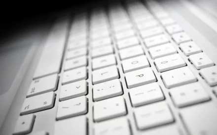 A close-up view of a white keyboard, showcasing its modern design and sleek keys, set against a subtle gradient background, serving as a striking HD PC desktop wallpaper.