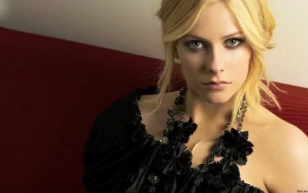 HD desktop wallpaper featuring Avril Lavigne in a black outfit, posing against a red background, emphasizing her music-themed persona.
