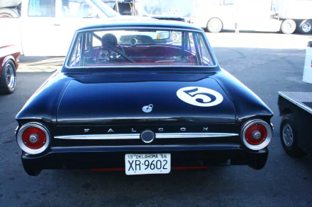 Rear view of a black Ford Falcon vehicle with racing number 5 and XR-9602 plate, presented as a 2K Quad HD PC desktop wallpaper/background.