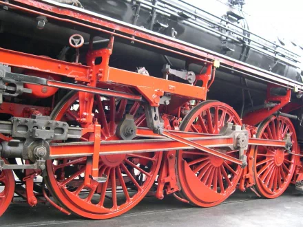 Close-up of a vibrant red steam train's wheel and mechanical components, captured in high definition for a striking PC desktop wallpaper background.