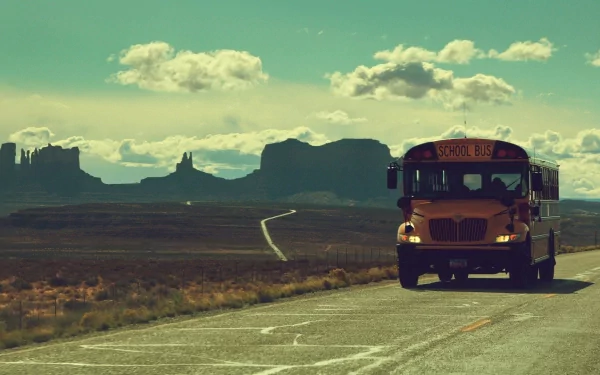 HD desktop wallpaper featuring a school bus on a road with a scenic mountainous backdrop.