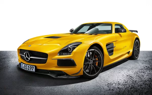 HD desktop wallpaper featuring a vibrant yellow Mercedes-Benz SLS AMG sports car on a textured gray surface with a white background.
