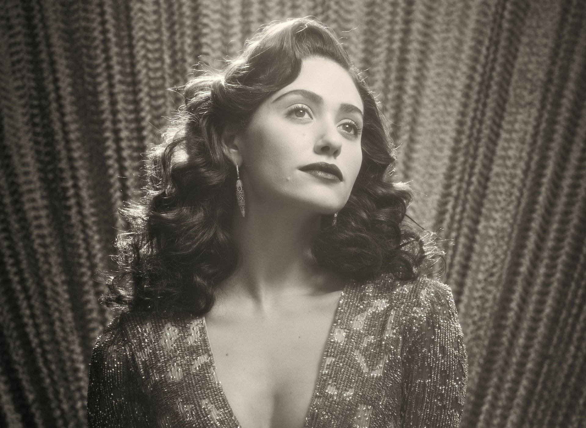 Black and white HD desktop wallpaper featuring celebrity Emmy Rossum with vintage waves and glamorous attire against a textured curtain backdrop.