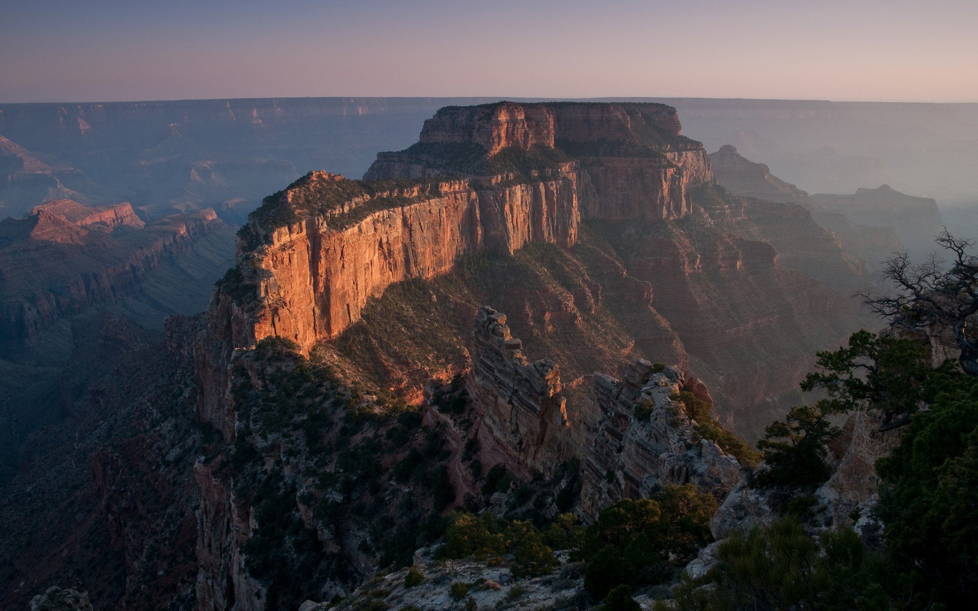 Nature Grand Canyon HD PC desktop wallpaper and background: sunlit cliffs and layered ridges at golden hour under a soft pastel sky.