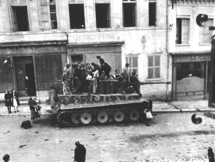 Black and white HD desktop wallpaper showing a World War II Tiger I tank surrounded by soldiers on a city street, capturing a historic military moment.