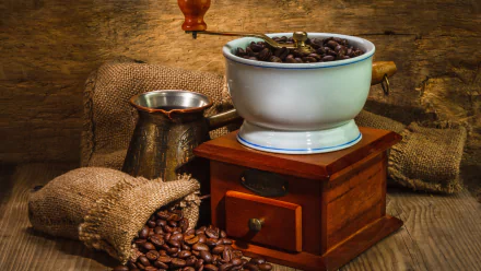 A rustic setup featuring a vintage coffee grinder, a copper pot, and burlap sacks filled with coffee beans, creating an inviting food and coffee-themed HD desktop wallpaper.