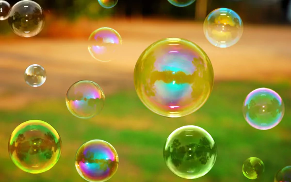 A vibrant close-up of colorful bubbles floating above a lush green background, captured in high definition for a stunning desktop wallpaper.