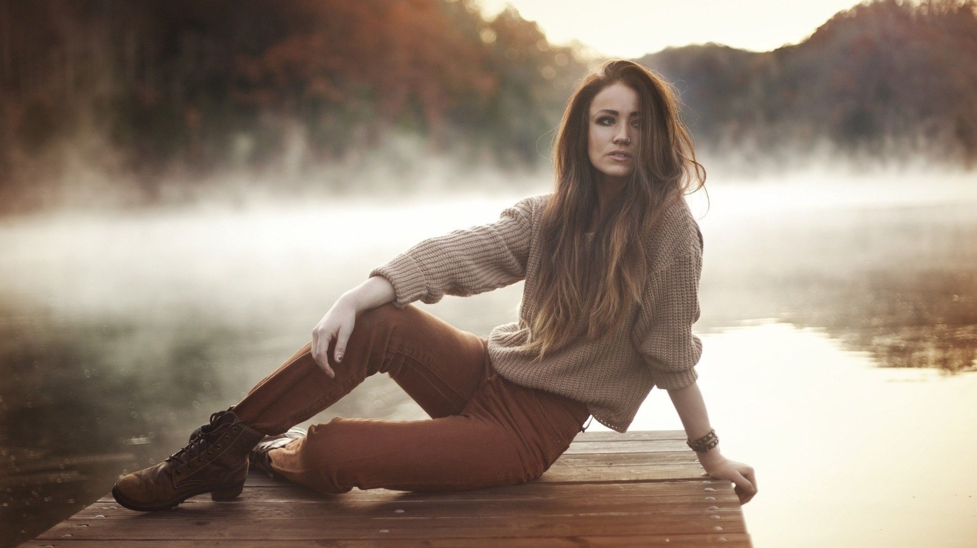 A woman model poses on a wooden dock, surrounded by misty water and autumn scenery, creating a serene and captivating atmosphere in this HD PC desktop wallpaper.