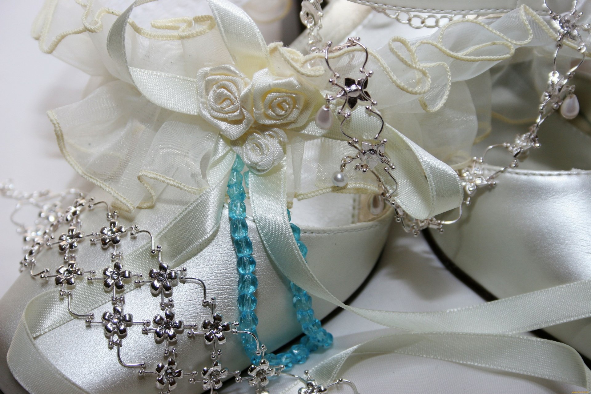 Close-up of elegant man-made jewelry featuring pearls, silver chains, and floral accents, captured in a 4K Ultra HD PC desktop wallpaper and background.