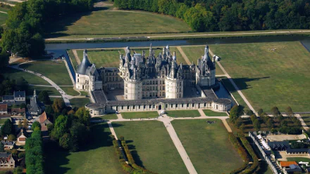 Aerial view of the man-made Château de Chambord surrounded by expansive green gardens, captured in HD for a stunning PC desktop wallpaper.