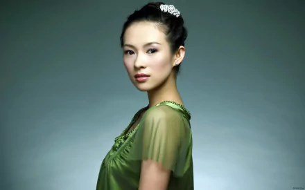 A high-definition desktop wallpaper featuring Zhang Ziyi, showcasing her elegance in a flowing green top against a soft, muted background.
