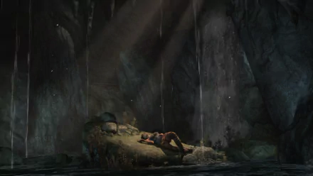 HD PC desktop wallpaper: Lara Croft from Tomb Raider (2013) rests on a rocky bank inside a dim cave, shafts of light and dripping water framing the atmospheric video game scene.