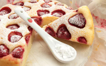A delicious pie with strawberries, dusted with powdered sugar, showcases a slice cut out and a small spoon beside it, creating an inviting food-themed HD PC desktop wallpaper.