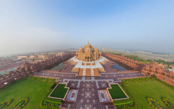 A stunning HD wallpaper featuring the majestic Akshardham temple, surrounded by lush gardens and intricate pathways, capturing the beauty of this religious landmark.