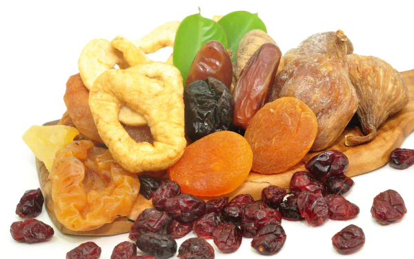 A vibrant assortment of dried fruits, including apricots, figs, and cranberries, arranged on a wooden surface. This HD desktop wallpaper showcases the rich textures and colors of healthy snacks.