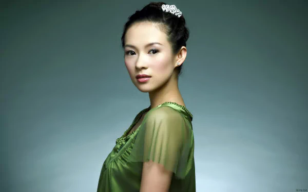 A high-definition desktop wallpaper featuring Zhang Ziyi, showcasing her elegance in a flowing green top against a soft, muted background.