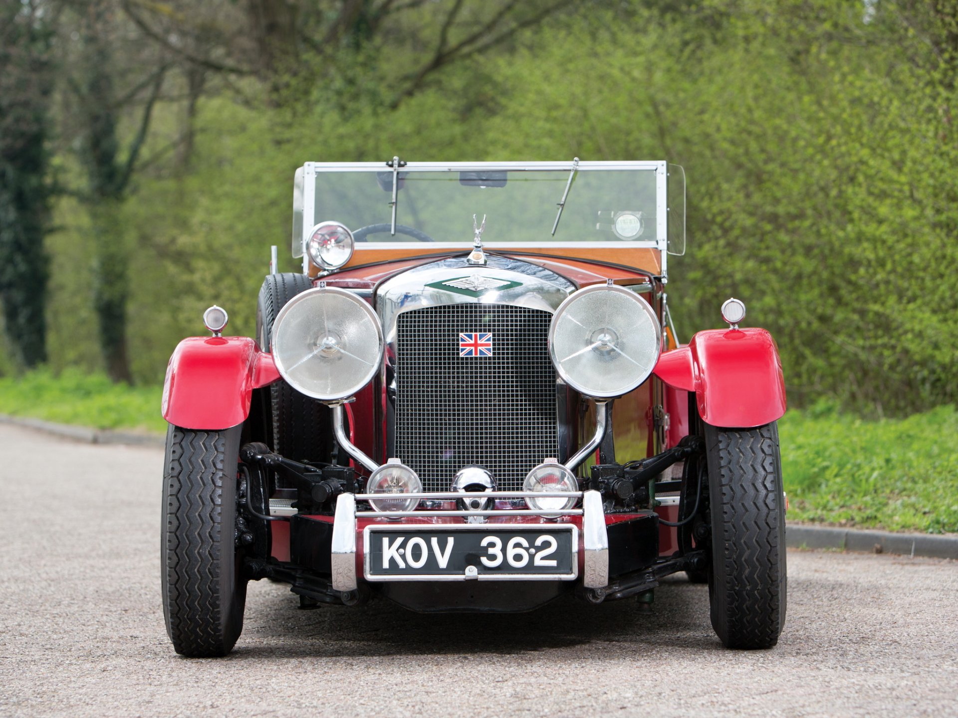 Front view of a red vintage Austin vehicle with British badge and license plate KOV 362 on a country road, HD PC desktop wallpaper/background.