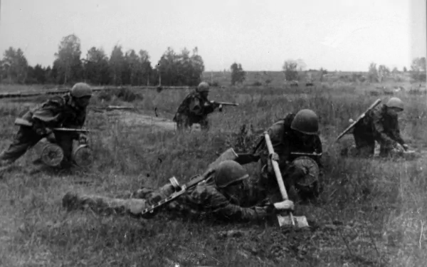 Black and white HD PC desktop wallpaper depicting soldiers in combat gear during the Vietnam War, moving tactically across a grassy battlefield.