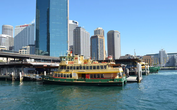 A vibrant ferry at Circular Quay, Sydney, surrounded by modern buildings and bustling wharfs, reflecting the lively harbor scene of Australia.