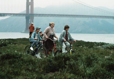 HD wallpaper of characters from Mrs. Doubtfire on a bike ride with the Golden Gate Bridge in the background.