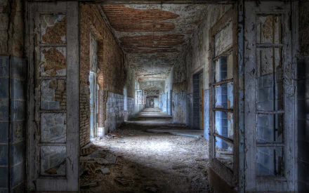 HD PC desktop wallpaper showing a long, decaying corridor of a man-made ruin with peeling walls and debris scattered along the floor.