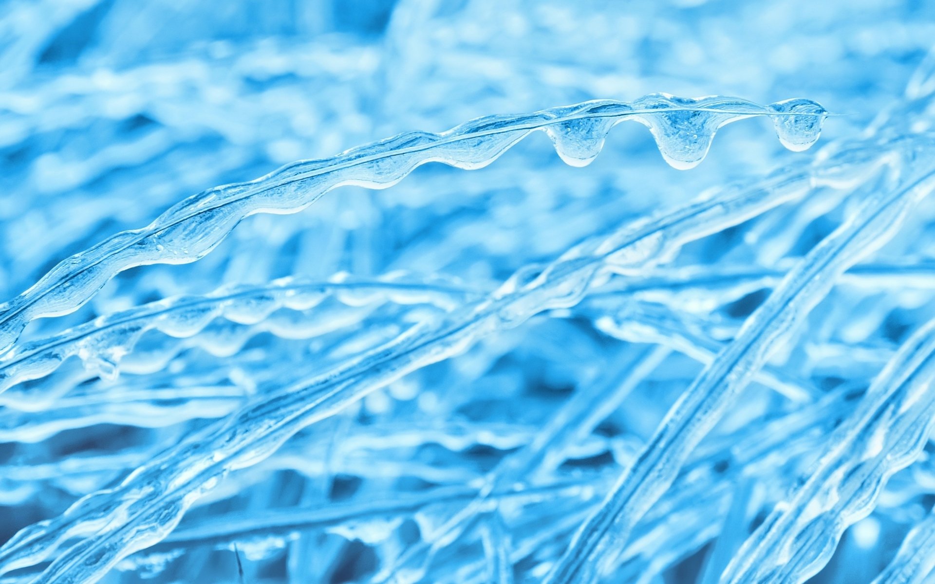 HD PC desktop wallpaper featuring a close-up of nature's icy formations with smooth, clear ice strands glistening in cool blue tones.
