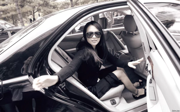Black-and-white HD desktop wallpaper featuring celebrity Zhang Ziyi stepping out of a car, wearing sunglasses and a black outfit.
