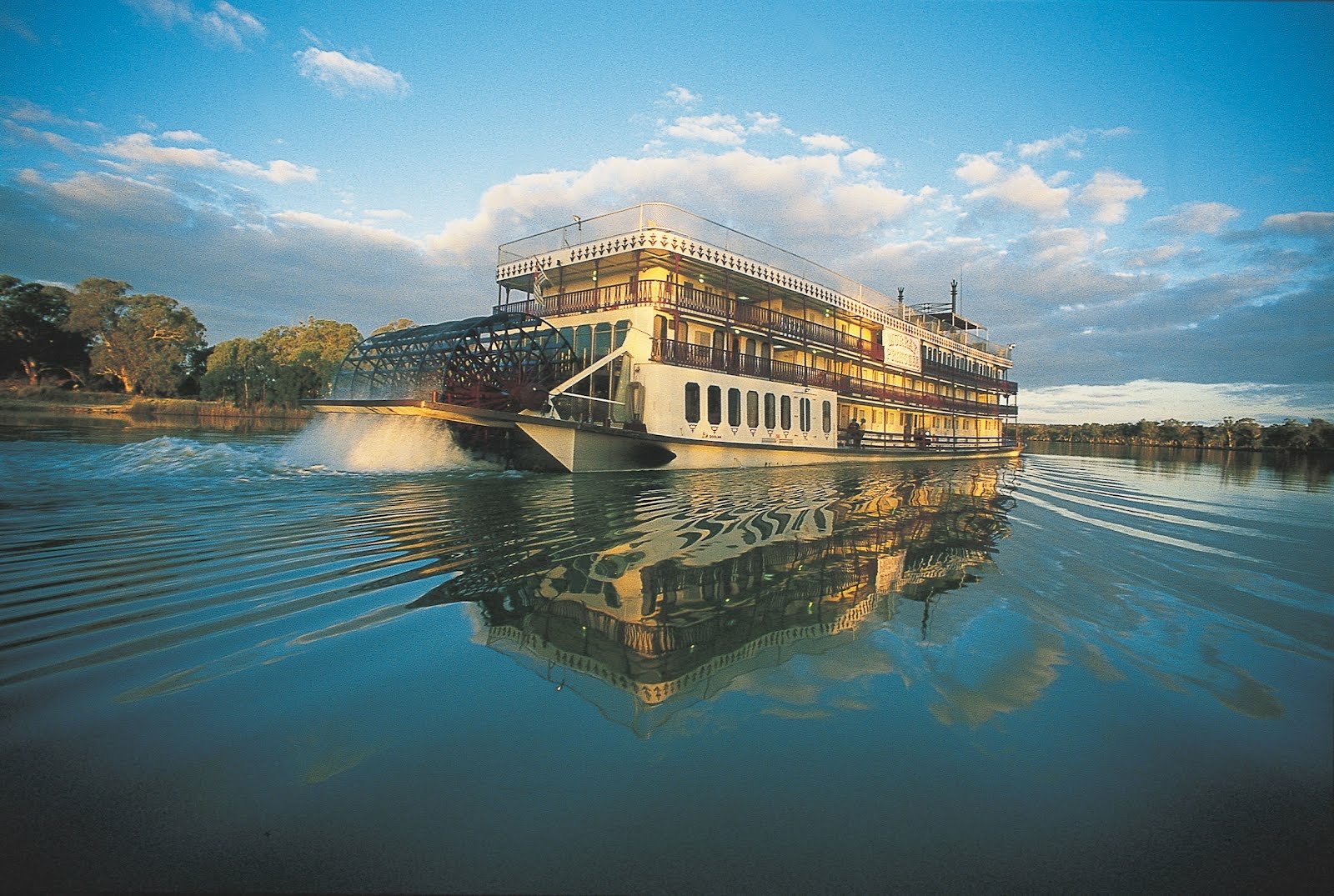 Paddle steamer boat gliding across a calm river at sunrise, mirrored in the water, a river vehicle — HD PC desktop wallpaper and background.
