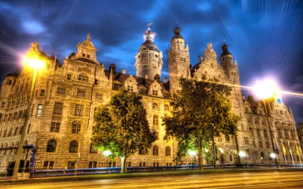 A stunning HD wallpaper of a majestic palace, showcasing intricate architecture under a dramatic evening sky, illuminated by street lights and surrounded by lush greenery.