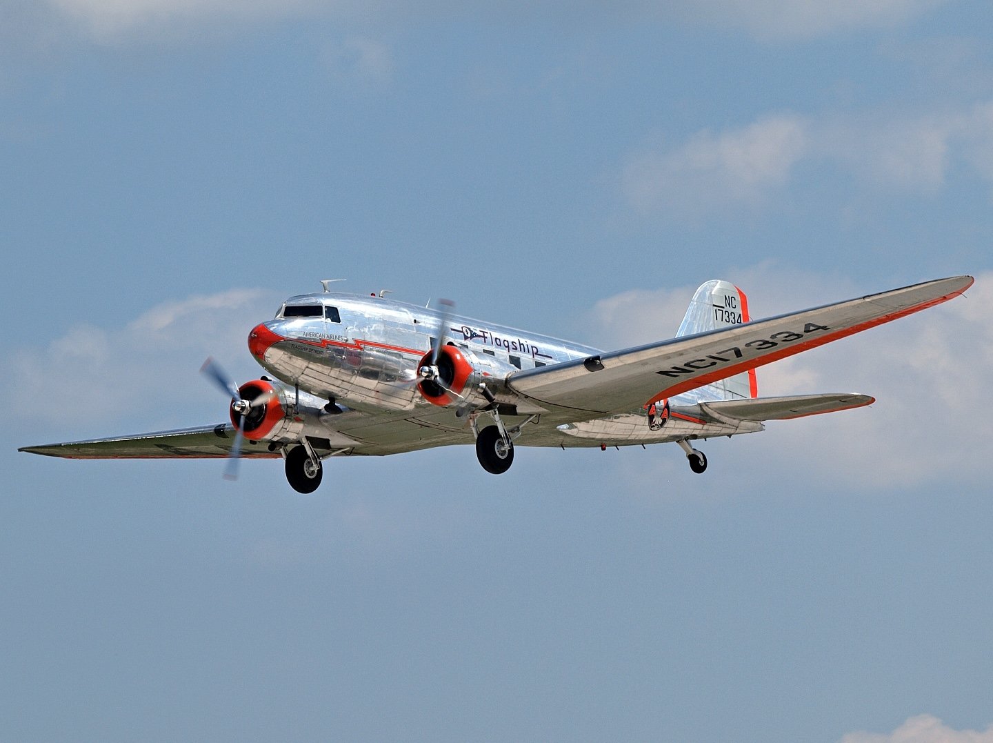 HD PC desktop wallpaper of a vintage Douglas DC-3 aircraft flying against a clear blue sky.