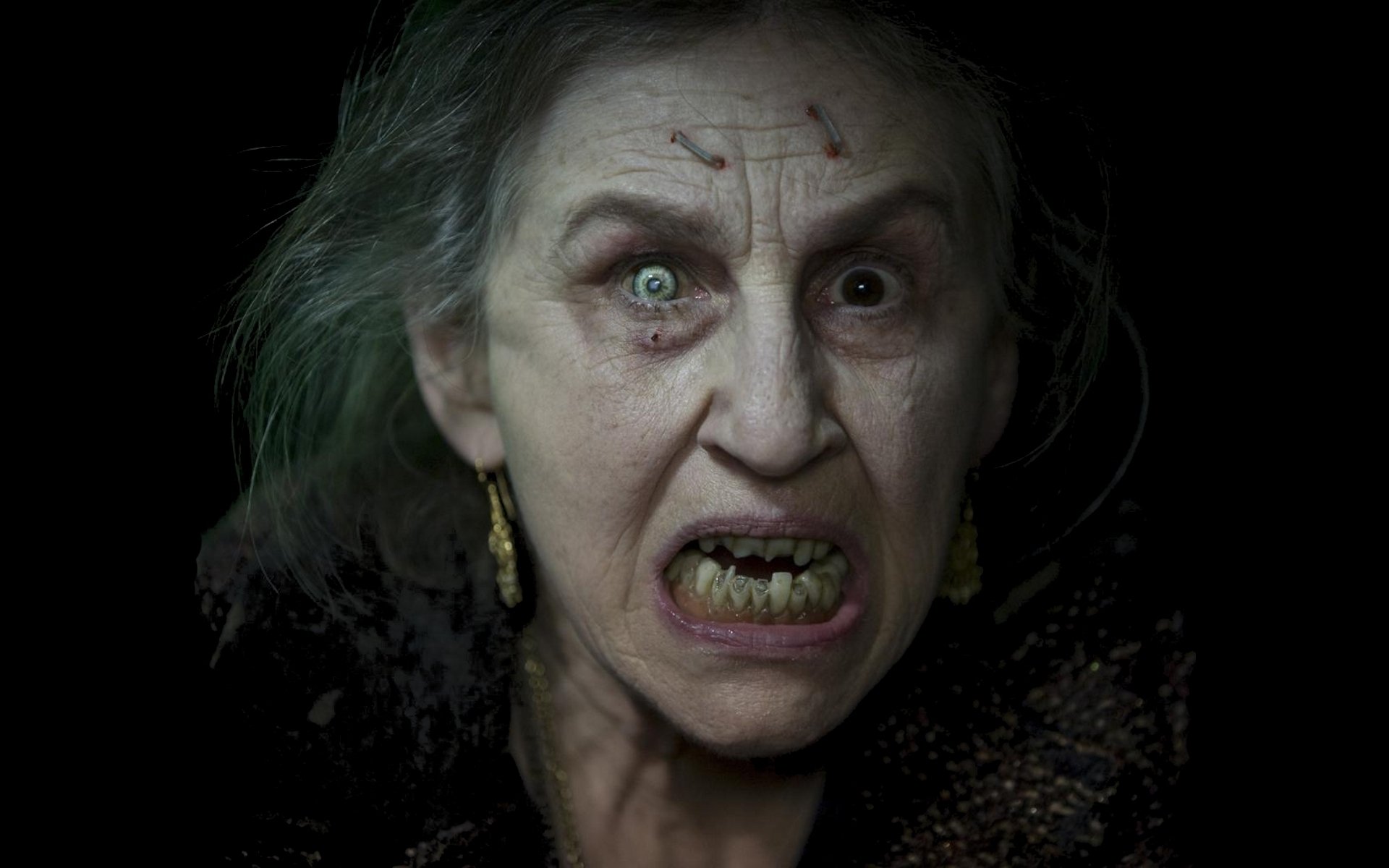 HD PC desktop wallpaper featuring a terrifying close-up from the movie Drag Me to Hell, capturing an exorcist-themed horror scene.