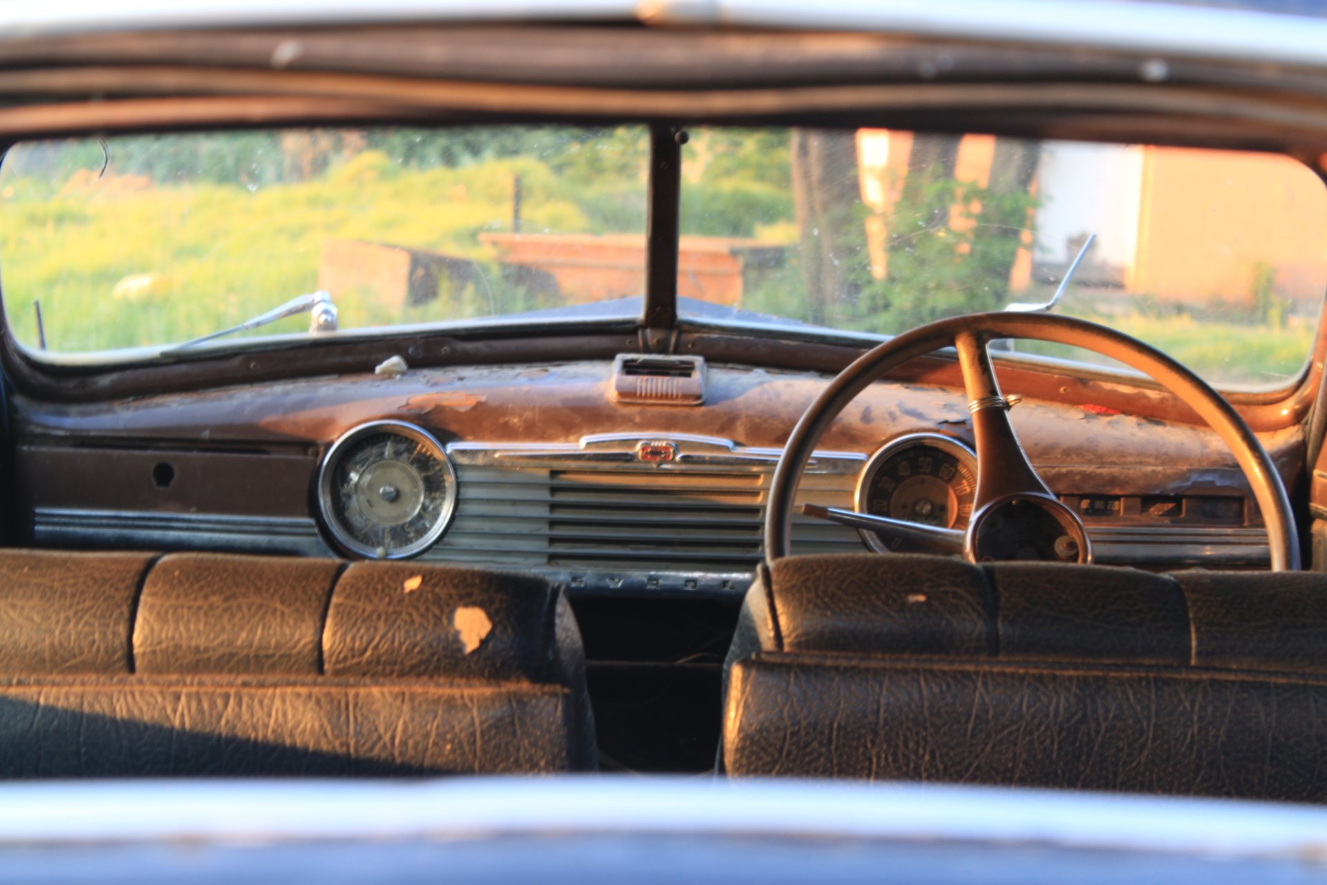 4K Ultra HD PC desktop wallpaper: close-up of a vintage car interior, wooden dashboard and steering wheel bathed in warm light.