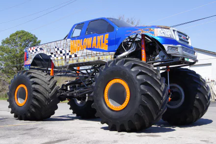 A vibrant monster truck with oversized tires, showcasing its powerful design. This HD desktop wallpaper captures the thrilling essence of off-road vehicles.