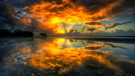 A stunning HD wallpaper featuring a vibrant sunset over calm water, with dramatic clouds and a beautiful reflection, showcasing the natural beauty of the scene.