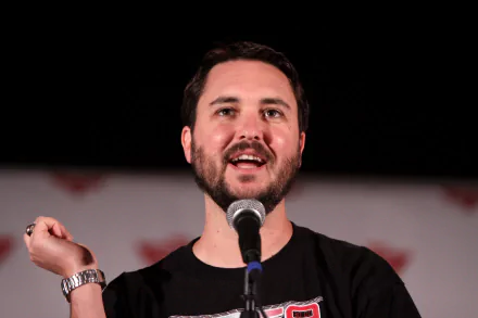 HD desktop wallpaper featuring a man with a microphone, smiling against a blurred background.