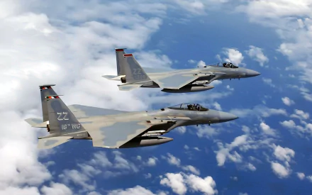 Two McDonnell Douglas F-15 Eagle fighters flying in military formation above clouds — HD PC desktop wallpaper/background.