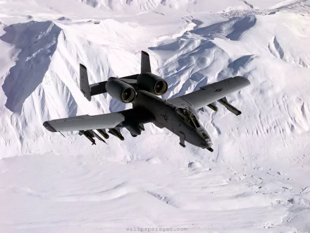 HD desktop wallpaper featuring a Fairchild Republic A-10 Thunderbolt II flying over snow-covered mountains in a military-themed scene.