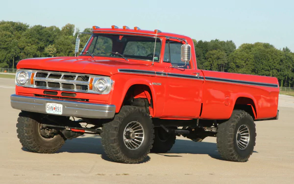 A vibrant red Dodge Power Wagon truck parked on a concrete surface with trees in the background, captured in 4K Ultra HD for PC desktop wallpaper.