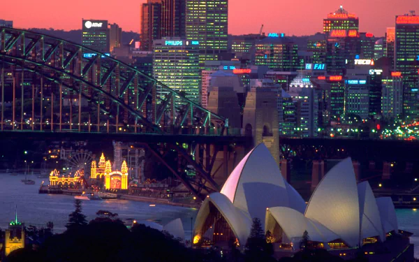 HD desktop wallpaper of Sydney at dusk: the man-made landmarks — illuminated Sydney Opera House, Luna Park by the harbour, Harbour Bridge and city skyline.