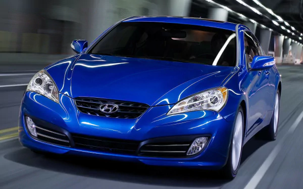 Blue Hyundai Genesis sedan speeding through a lit tunnel, HD PC desktop wallpaper/background showcasing the vehicle's sleek front profile.